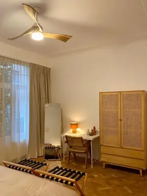 a bedroom with a bed and a desk and a ceiling fan at Completely renovated apartment in Antwerp