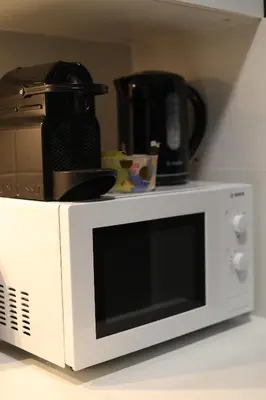 a microwave with a coffee pot on top of it at Cozy Apartment in Antwerp central in Antwerp