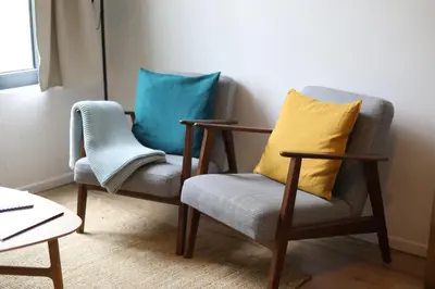 two chairs in a living room with blue pillows at Cozy Apartment in Antwerp central in Antwerp