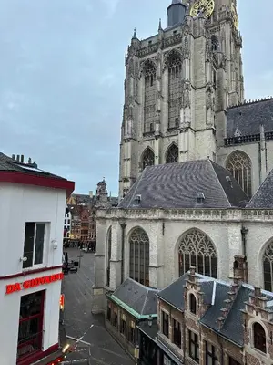 a large cathedral with a clock tower in a city at Charming Apartment with Cathedral View! On the 4th floor in Antwerp