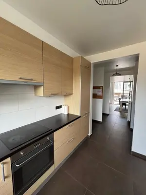 a kitchen with wooden cabinets and black counter tops at Stylish, modern & spacious apartment in Brussels in Brussels