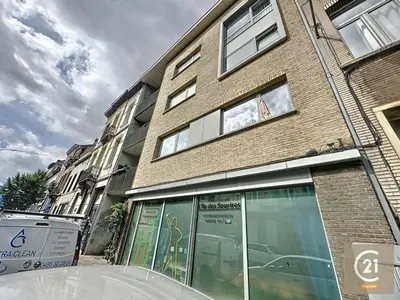 a large brick building with windows on a street at Stylish, modern & spacious apartment in Brussels in Brussels