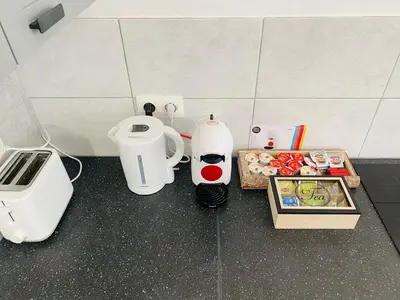 a counter with two coffee makers and a box of food at Studio calme et lumineux à Uccle in Brussels