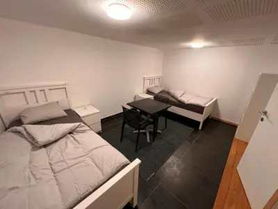 a room with two beds and a table in it at Doppelzimmer im Herzen Brüssels in Brussels