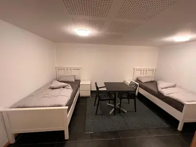 a room with two beds and a table in it at Doppelzimmer im Herzen Brüssels in Brussels