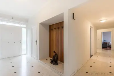 a hallway with white walls and a wooden door at Holiday home Zelenachten in Zele