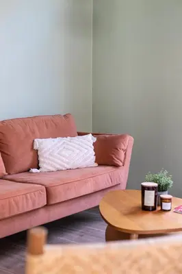 a brown couch in a living room with a table at Chic 3BR Apartment near Antwerpen-Centraal Station in Antwerp