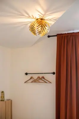 a light hanging from a ceiling in a room at Chic 3BR Apartment near Antwerpen-Centraal Station in Antwerp
