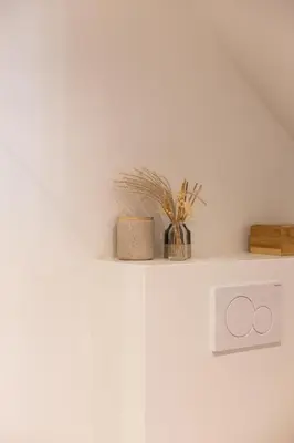 a white shelf with a plant on top of it at Chic 3BR Apartment near Antwerpen-Centraal Station in Antwerp