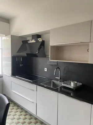 a kitchen with white cabinets and a sink at JV House in Zellik