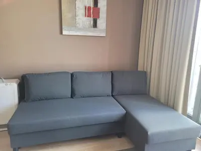 a blue couch in a room with a window at Botanical Garden Rogier Brussels in Brussels