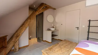 a bedroom with white walls and a staircase with a mirror at Gezellig vakantiehuis voor 12 personen in Boutersem