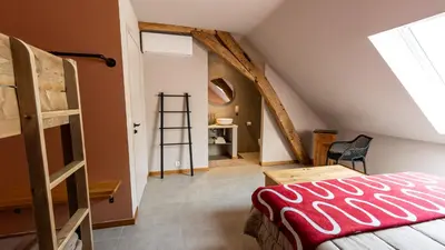 a bedroom with a ladder and a bunk bed in a attic at Gezellig vakantiehuis voor 12 personen in Boutersem