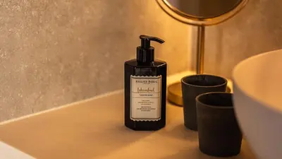 a bottle of hand soap sitting on a bathroom counter at Gezellig vakantiehuis voor 12 personen in Boutersem