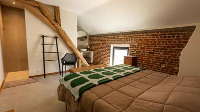 a bedroom with a bed and a brick wall at Gezellig vakantiehuis voor 12 personen in Boutersem