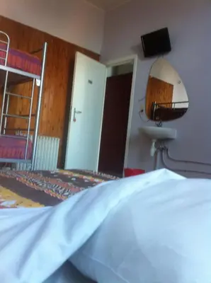 a bedroom with a bed and a tv on the wall at The82 Hostel Louise in Brussels