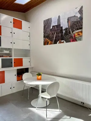 a dining room with a white table and two chairs at Studio vintage banlieue BXL in Genval