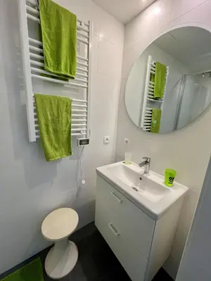 a white bathroom with a sink and a mirror at Studio vintage banlieue BXL in Genval