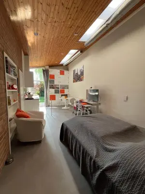 a bedroom with a bed and a couch and a table at Studio vintage banlieue BXL in Genval