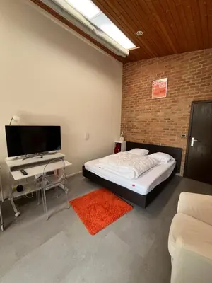 a bedroom with a bed and a flat screen tv at Studio vintage banlieue BXL in Genval