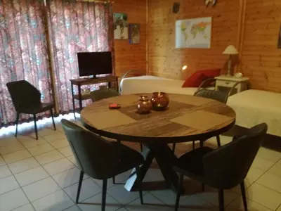 a living room with a table and a bed and a bedroom at De Zon B&B in Heist-op-den-Berg