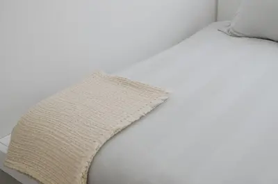 a white bed with a blanket on top of it at Appartement t'Zuid with underground parking in Antwerp