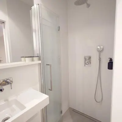 a white bathroom with a shower and a sink at Appartement t'Zuid with underground parking in Antwerp