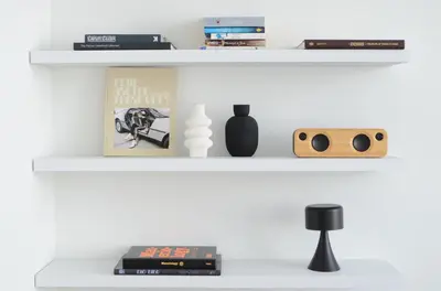 a shelf with dvds and a book and a speaker at Appartement t'Zuid with underground parking in Antwerp