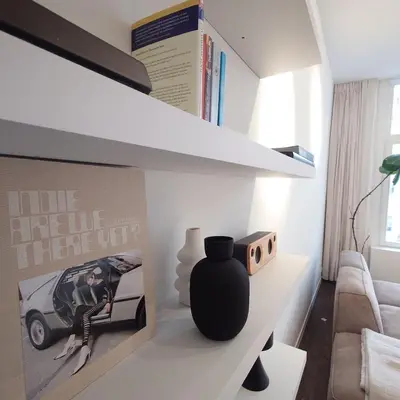 a living room with a black vase on a white shelf at Appartement t'Zuid with underground parking in Antwerp