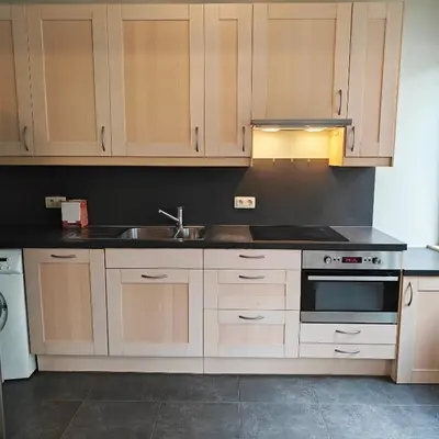 a kitchen with wooden cabinets and a sink at Splendid 2 bedroom apartment in Etterbeek in Brussels