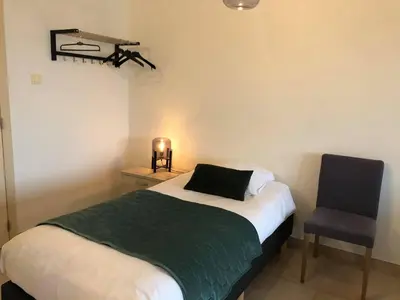 a small bedroom with a bed and a chair at Apartment Fruithof Tack in Sint-Gillis-Waas
