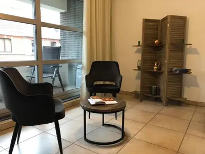 two chairs and a table in a room with a window at Apartment Fruithof Tack in Sint-Gillis-Waas