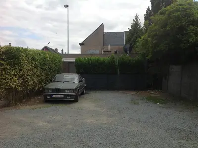 a car parked in a driveway in front of a house at Apartment Fruithof Tack in Sint-Gillis-Waas