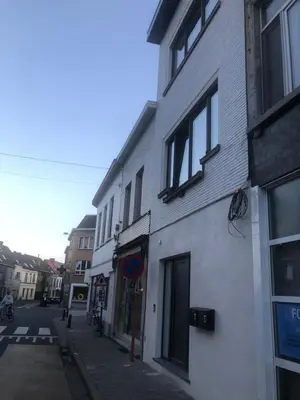 a white building on the side of a street at Holiday Small Shared Room in Gent in Ghent