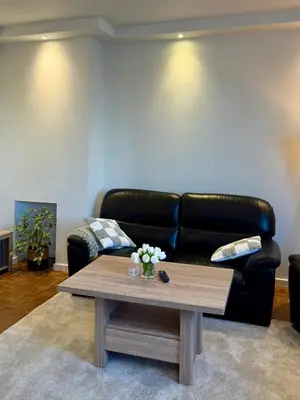 a living room with a black leather couch and a coffee table at Arm Apart in Brussels
