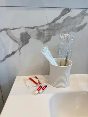a bathroom counter with toothbrushes and a cup of toothpaste at Arm Apart in Brussels