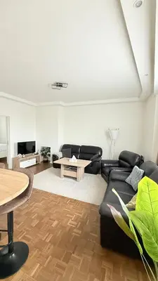 a living room with a black couch and a table at Arm Apart in Brussels