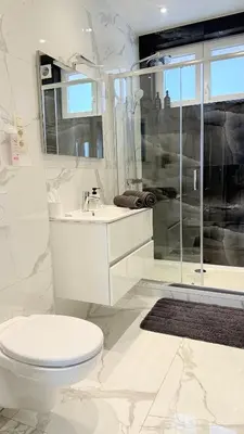 a white bathroom with a toilet and a shower at Arm Apart in Brussels