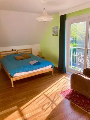 a bedroom with a bed and a large window at Family home, green surroundings, 10 min from Brussels in Overijse