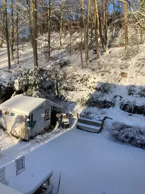 an rv parked in a yard covered in snow at Family home, green surroundings, 10 min from Brussels in Overijse