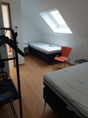 a bedroom with a bed and a red chair at Krie 2 by Luttelkolen in Tielt