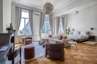 a living room with a couch and a table and chairs at Mas Europe by Sweett in Brussels