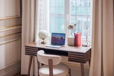a desk with a laptop and a chair next to a window at Mas Europe by Sweett in Brussels