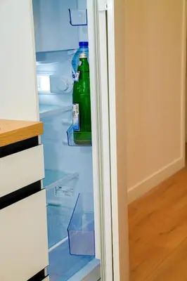 a bottle of water in an empty refrigerator at Lovely 1BR & 1LR Apt for 4P, Only 15 Min Walk to City Center in Ghent