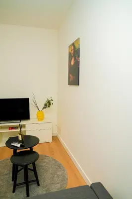 a living room with a couch and a table and a tv at Lovely 1BR & 1LR Apt for 4P, Only 15 Min Walk to City Center in Ghent