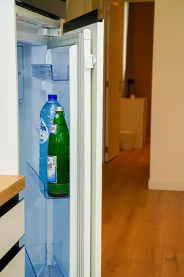 a bottle of water is inside of an empty refrigerator at Lovely 1BR & 1LR Apt for 4P, Only 15 Min Walk to City Center in Ghent