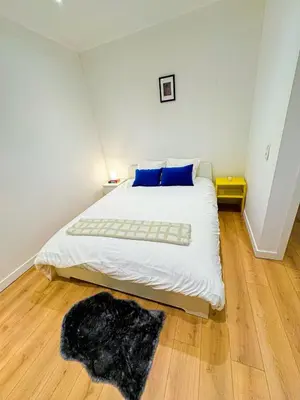 a bedroom with a large white bed with blue pillows at Lovely 1BR & 1LR Apt for 4P, Only 15 Min Walk to City Center in Ghent