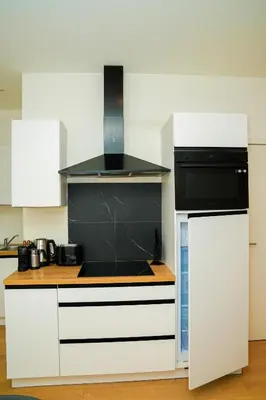 a kitchen with white cabinets and a stove top oven at Lovely 1BR & 1LR Apt for 4P, Only 15 Min Walk to City Center in Ghent