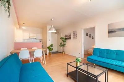a living room with a blue couch and a table at Bright and Central Antwerp Apartments in Antwerp