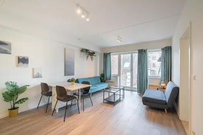 a living room with a table and a blue couch at Bright and Central Antwerp Apartments in Antwerp